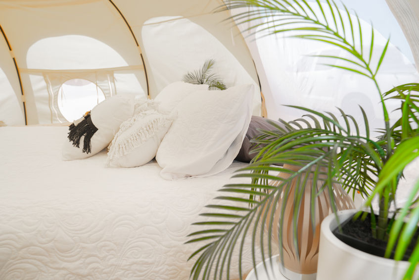 A close up of a luxury bed in a bell tent