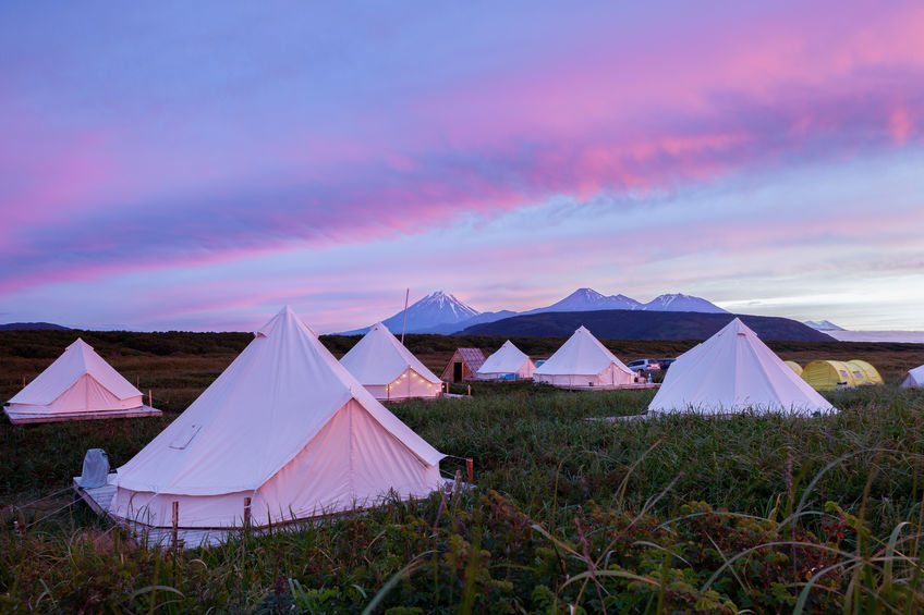 A glampsite full of bell tents at sunset