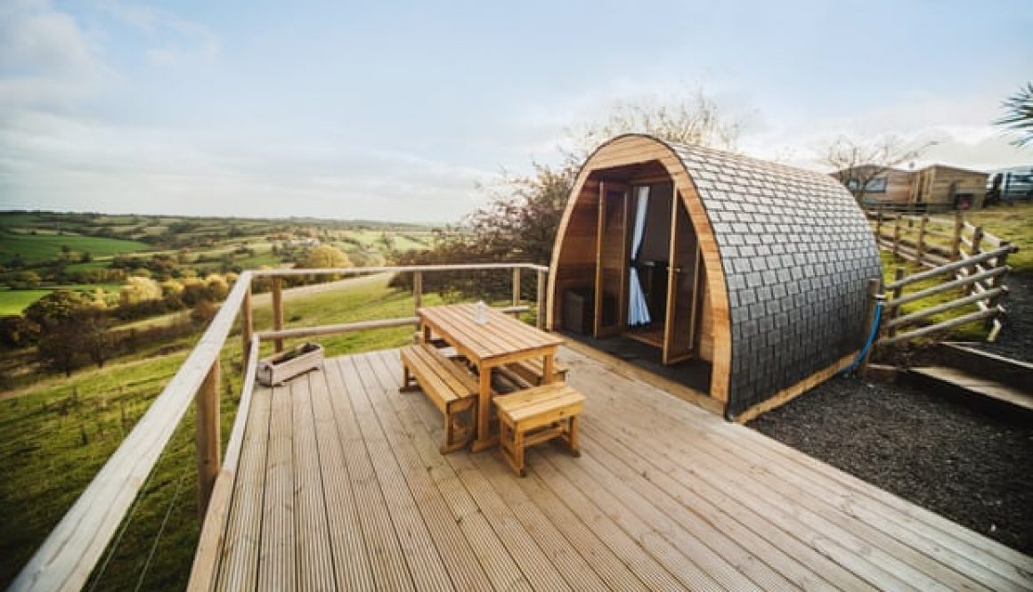 A glamping pod against a background of fields.