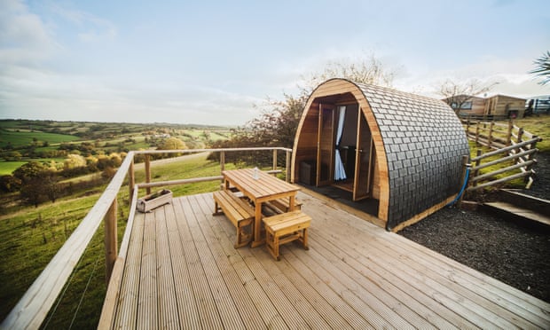 A glamping pod against a background of fields.