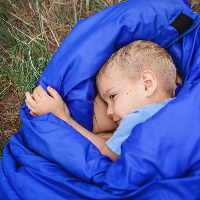 A boy in a blue sleeping bag