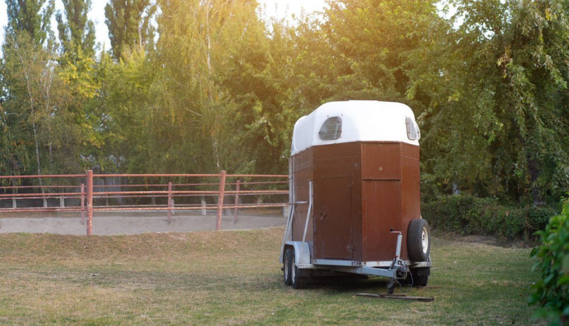 A horsebox stood in a green field.