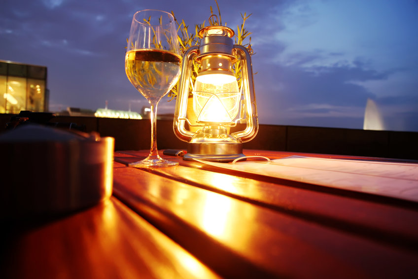 A glass of white wine besides a lantern