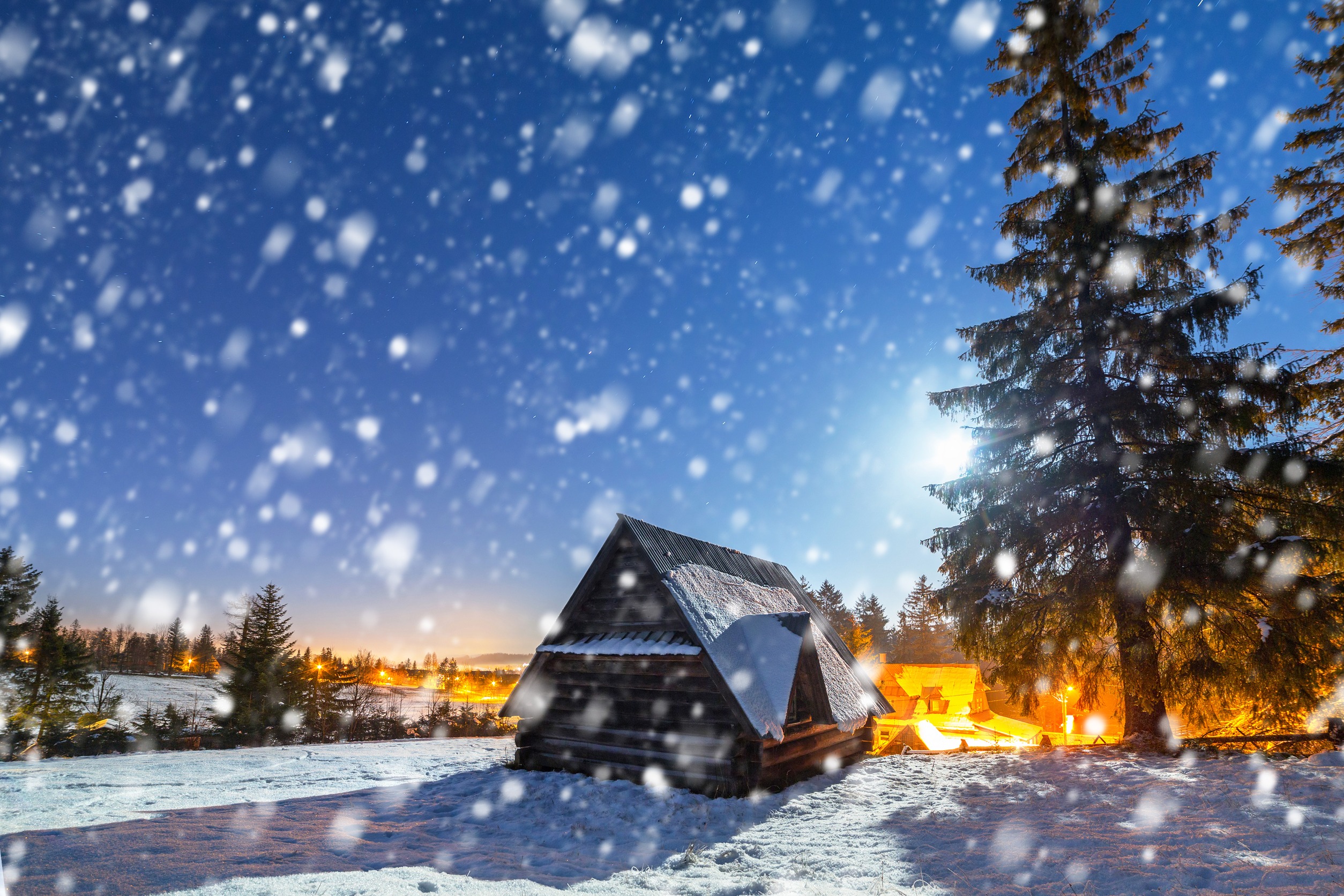 A log cabin viewed through a flurry of snow.